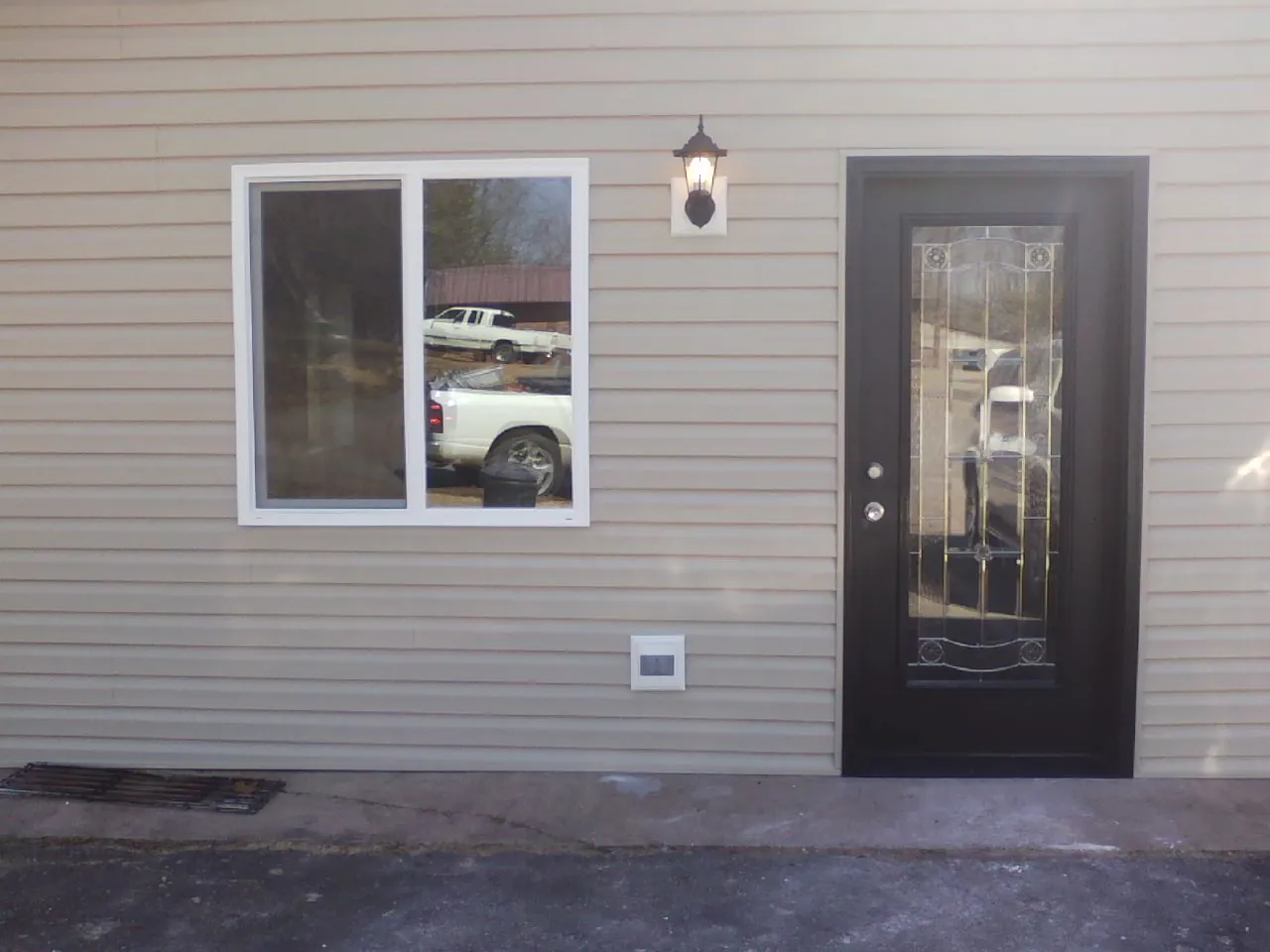 New siding, window and entry door on the side of an addition in Morganfield
