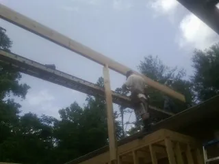 Carpenter setting a ridge beam over a new addition frame — Ice Dam Removal by Roofing Brothers in Morganfield