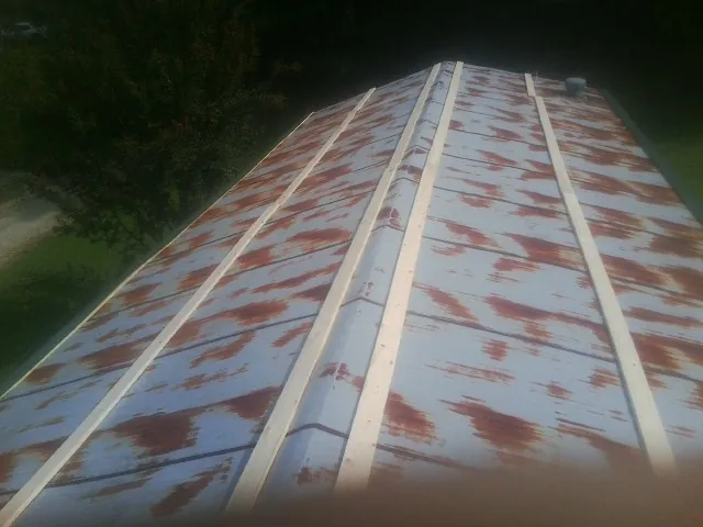 Rusted metal roof panels with new wood purlins before replacement — Storm Damage Roof Repair in Morganfield by Roofing Brothers