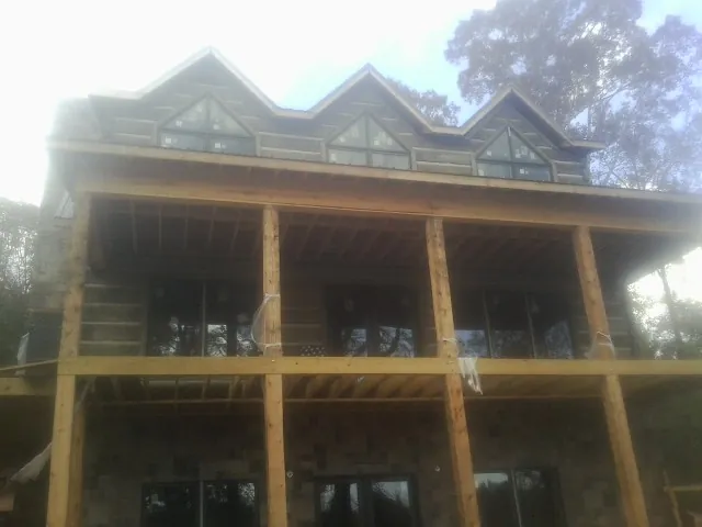 Dormers and porch framing on a large log home under construction — Roof Coating work by our crew in Morganfield