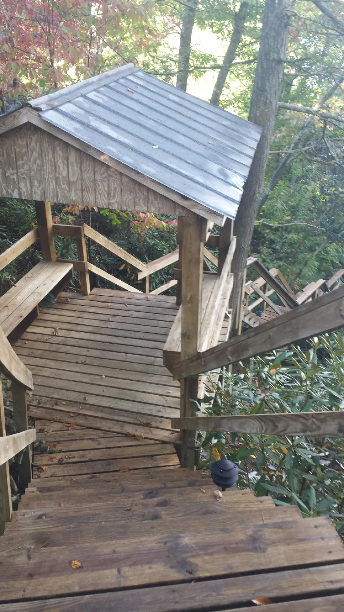 Metal roofed shelter over wooden steps on a wooded walkway — Skylight Repair & Installation work by our crew in Morganfield