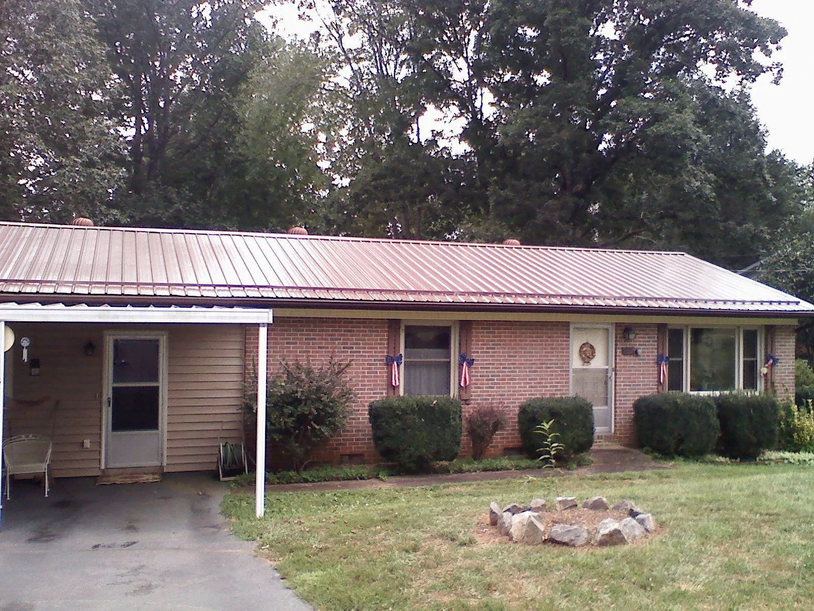 Bronze metal roof and carport on a brick ranch home — Roof Repair work by our crew in Morganfield