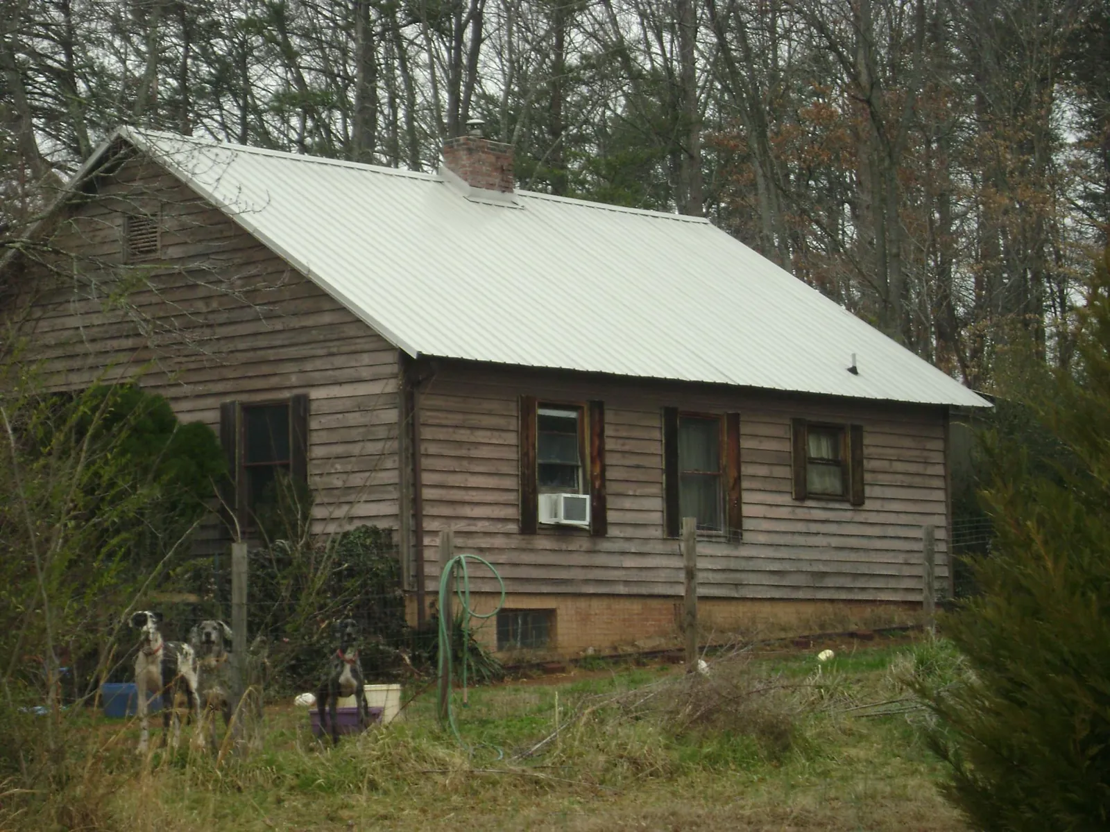 White metal roof on an old wood sided farmhouse, from a Metal Roof Installation job in Morganfield